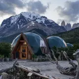 Strutture a cupola verde in un paesaggio montano, che incarnano il **glamping significato**: lusso e natura.