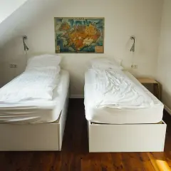 Camera con due letti singoli, mappa dell'Islanda appesa al muro. Un'idea per chi vuole sapere come aprire un ostello.
