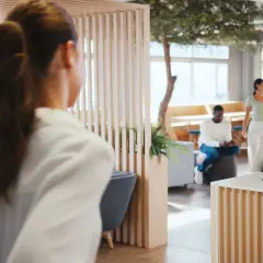 Receptionist sorridente con tablet, esempio di attività di back office. In attesa clienti in un ufficio moderno.