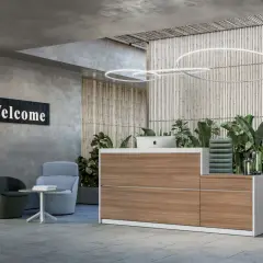 Reception hotel con bancone in legno, piante rigogliose e sedute accoglienti. I turni reception hotel sono gestiti con stile.
