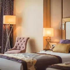 Camera da letto elegante con fiori freschi, ideale per annunci su Google Hotel Ads.