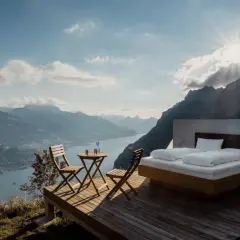 Vista mozzafiato da una casa vacanza: letto king-size, tavolino con sedie e panorama alpino. Pro e contro di un soggiorno così esclusivo.