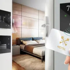 Ingresso in una smart room: una mano avvicina una tessera magnetica a un pannello digitale con il numero 704.