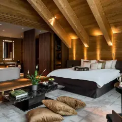 Lussuosa suite con bagno aperto, letto king-size e arredi in legno. Chissà quante stelle può avere un hotel così.