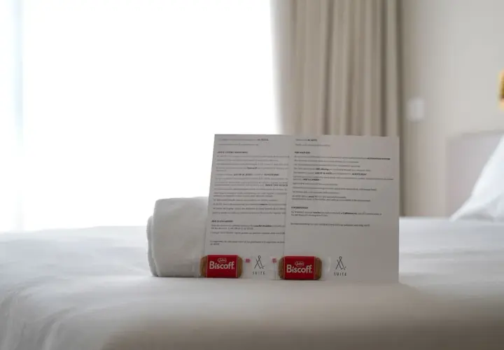 Biscotti Biscoff e un foglio informativo su come si scrive suite, su un letto bianco.