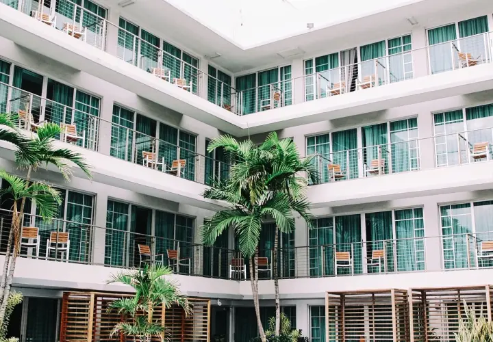 L'albergo, con le sue palme e balconi, evoca un senso di vacanza e relax.