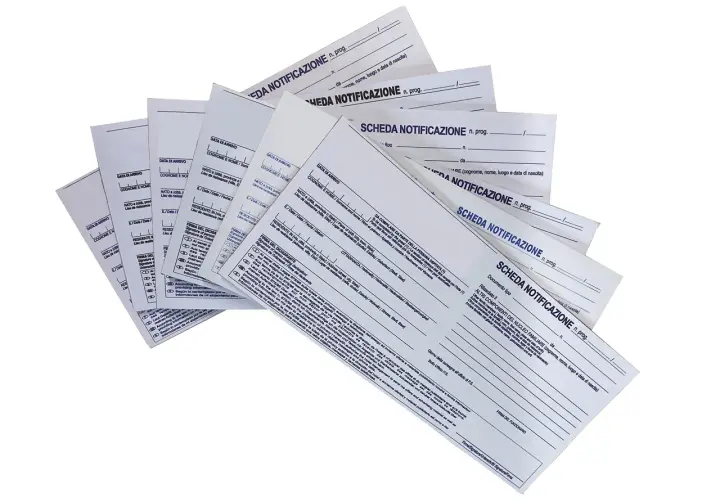 Pile di moduli "Scheda Notificazione" per hotel, con campi per dati anagrafici e di soggiorno.