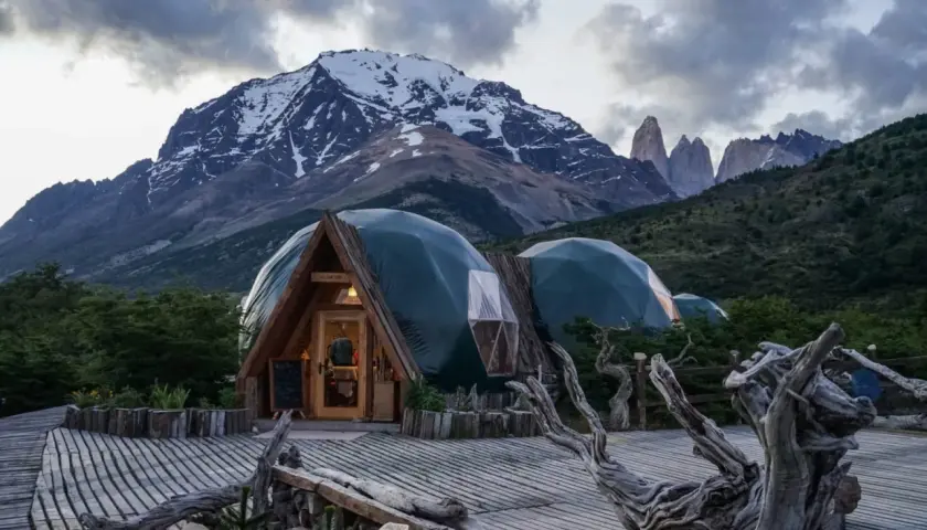 Strutture a cupola verde in un paesaggio montano, che incarnano il **glamping significato**: lusso e natura.