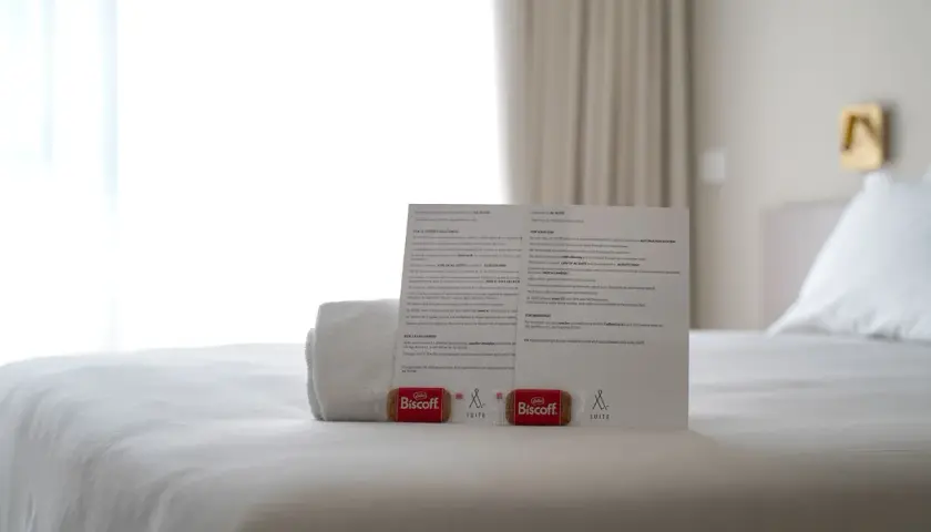 Biscotti Biscoff e un foglio informativo su come si scrive suite, su un letto bianco.