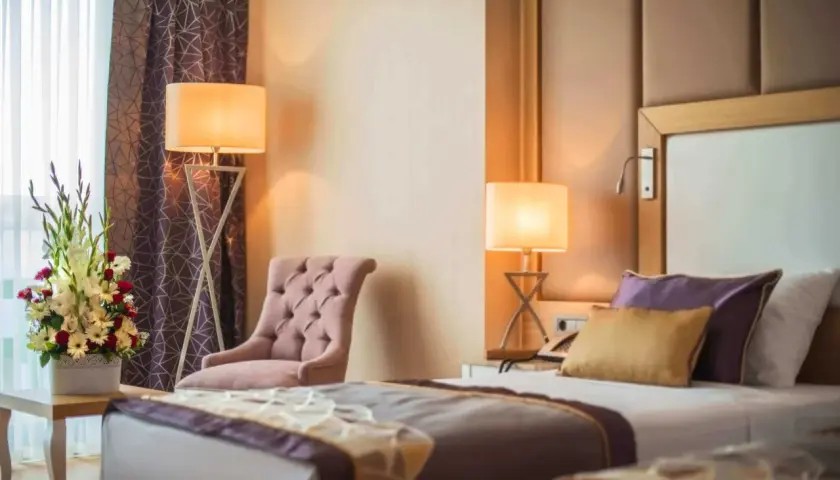 Camera da letto elegante con fiori freschi, ideale per annunci su Google Hotel Ads.