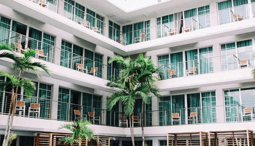 L'albergo, con le sue palme e balconi, evoca un senso di vacanza e relax.