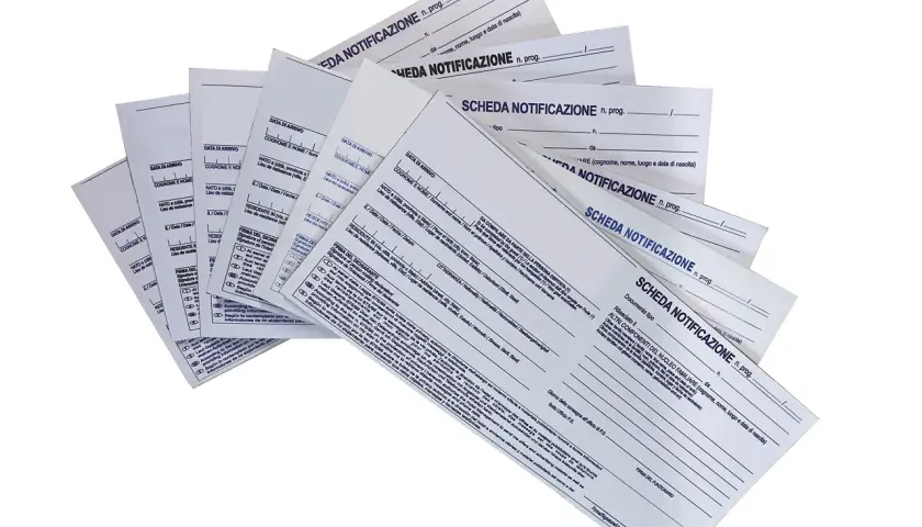Pile di moduli "Scheda Notificazione" per hotel, con campi per dati anagrafici e di soggiorno.