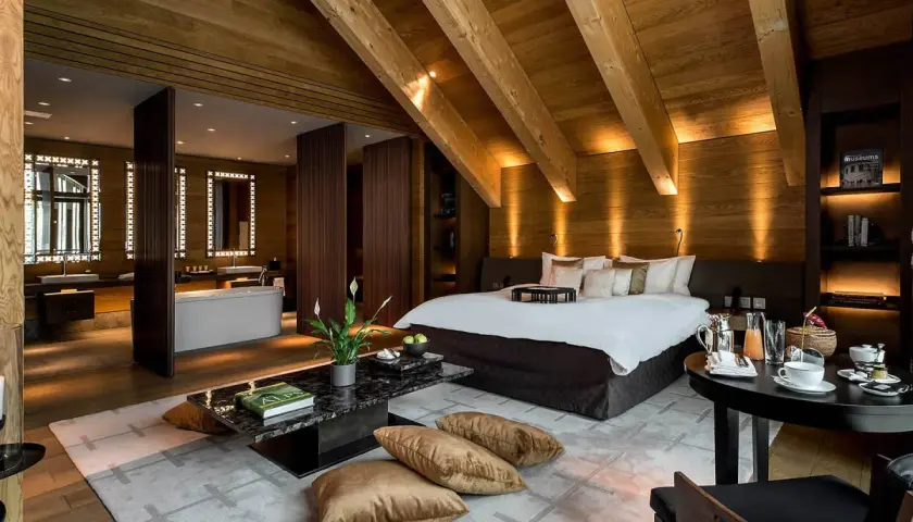 Lussuosa suite con bagno aperto, letto king-size e arredi in legno. Chissà quante stelle può avere un hotel così.