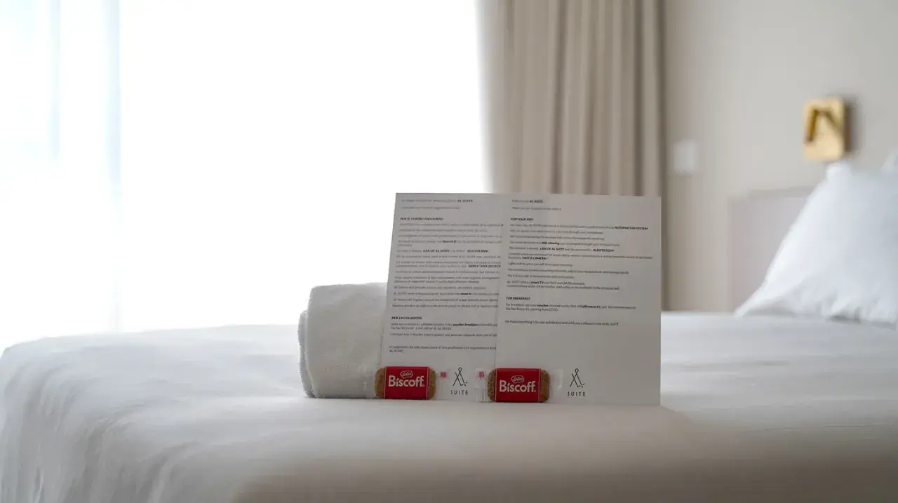 Biscotti Biscoff e un foglio informativo su come si scrive suite, su un letto bianco.