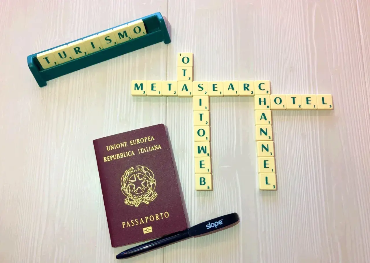 Un passaporto italiano, tessere di parole che formano "METASEARCH", "TURISMO", "HOTEL" e "CHANNEL". Strumenti per pianificare viaggi tramite metamotori di ricerca.