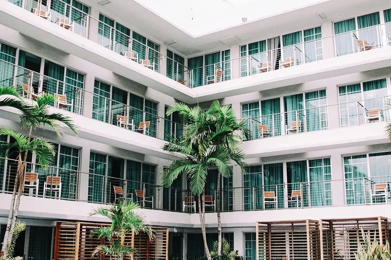 L'albergo, con le sue palme e balconi, evoca un senso di vacanza e relax.
