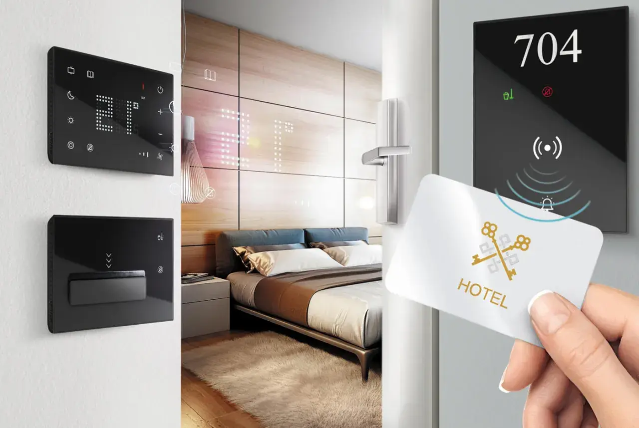 Ingresso in una smart room: una mano avvicina una tessera magnetica a un pannello digitale con il numero 704.