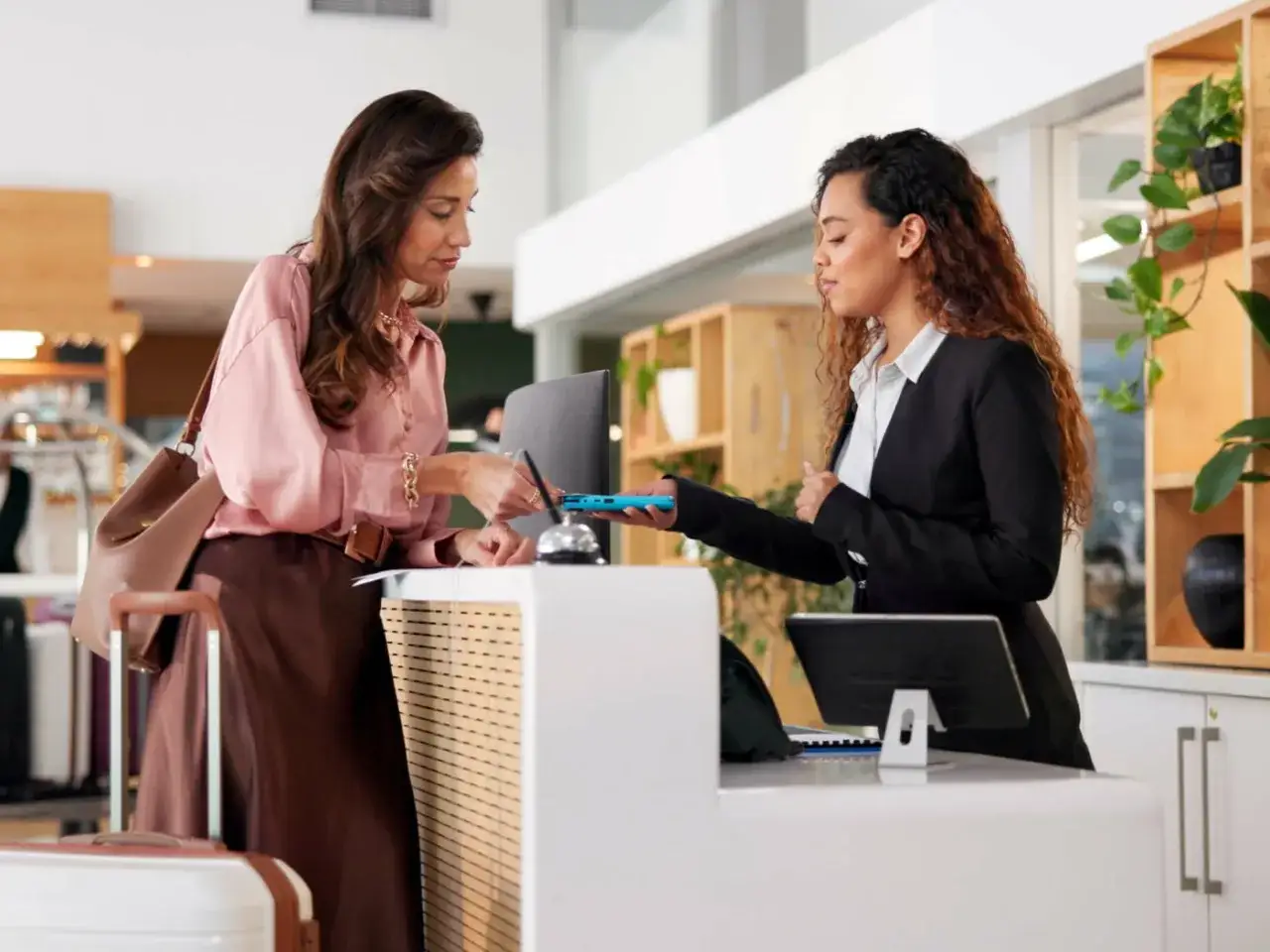La cliente effettua il check-out alla reception, pagando con il suo telefono.