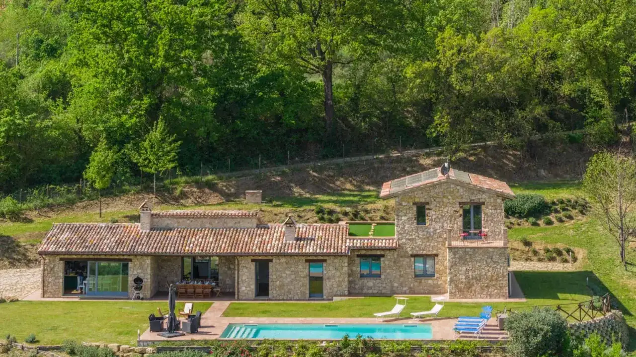 Ville in pietra con piscina e giardino lussureggiante, ideali come strutture ricettive per vacanze rilassanti.