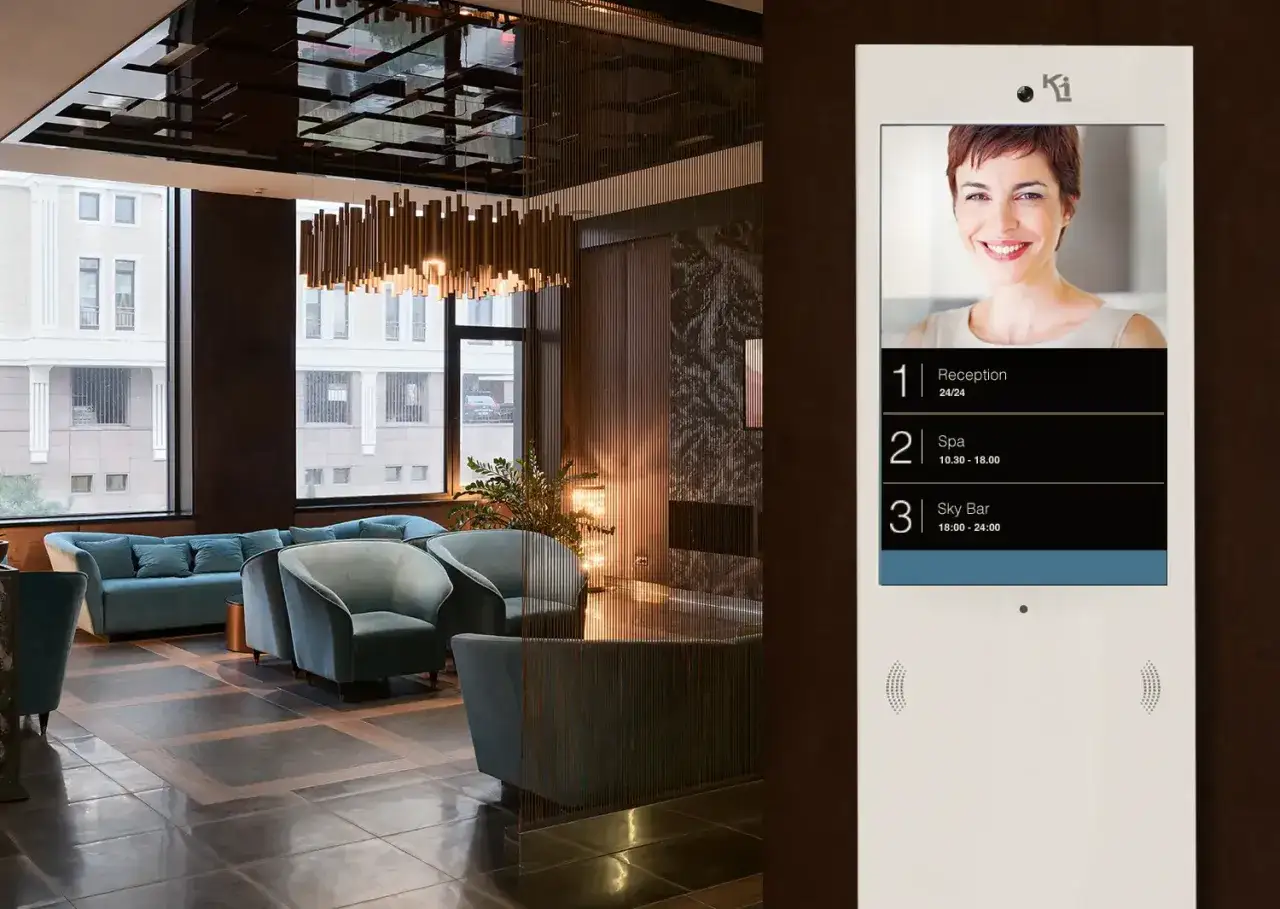 Lobby moderno con divani blu e un pannello informativo che mostra i servizi dell'hotel, inclusa la reception, per gli ospiti istat alloggiati.